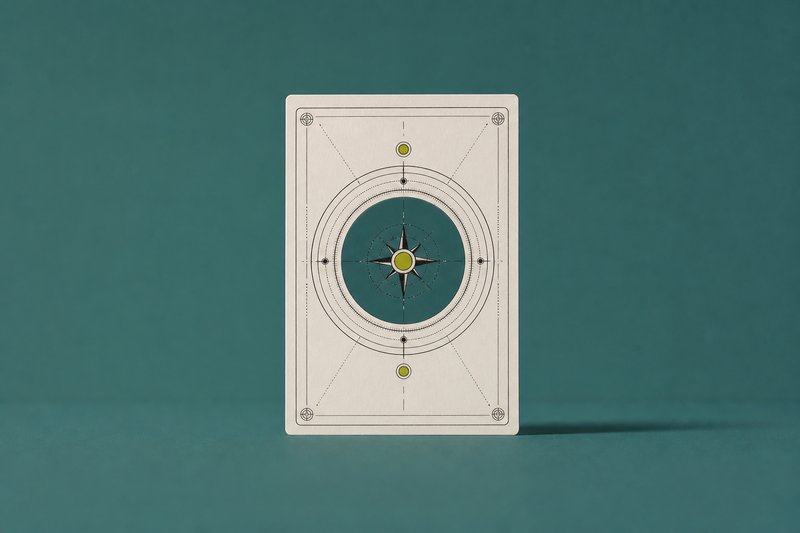 A single bone card standing upright on a wide empty petrol teal field, casting a long shadow.
